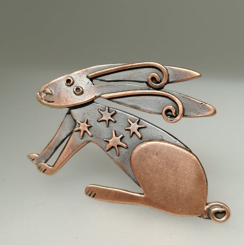 Copper coloured hare brooch with stars on its body handmade by Sharon McSwiney